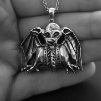 handmade sterling silver bat-grotesque necklace in hand of model 