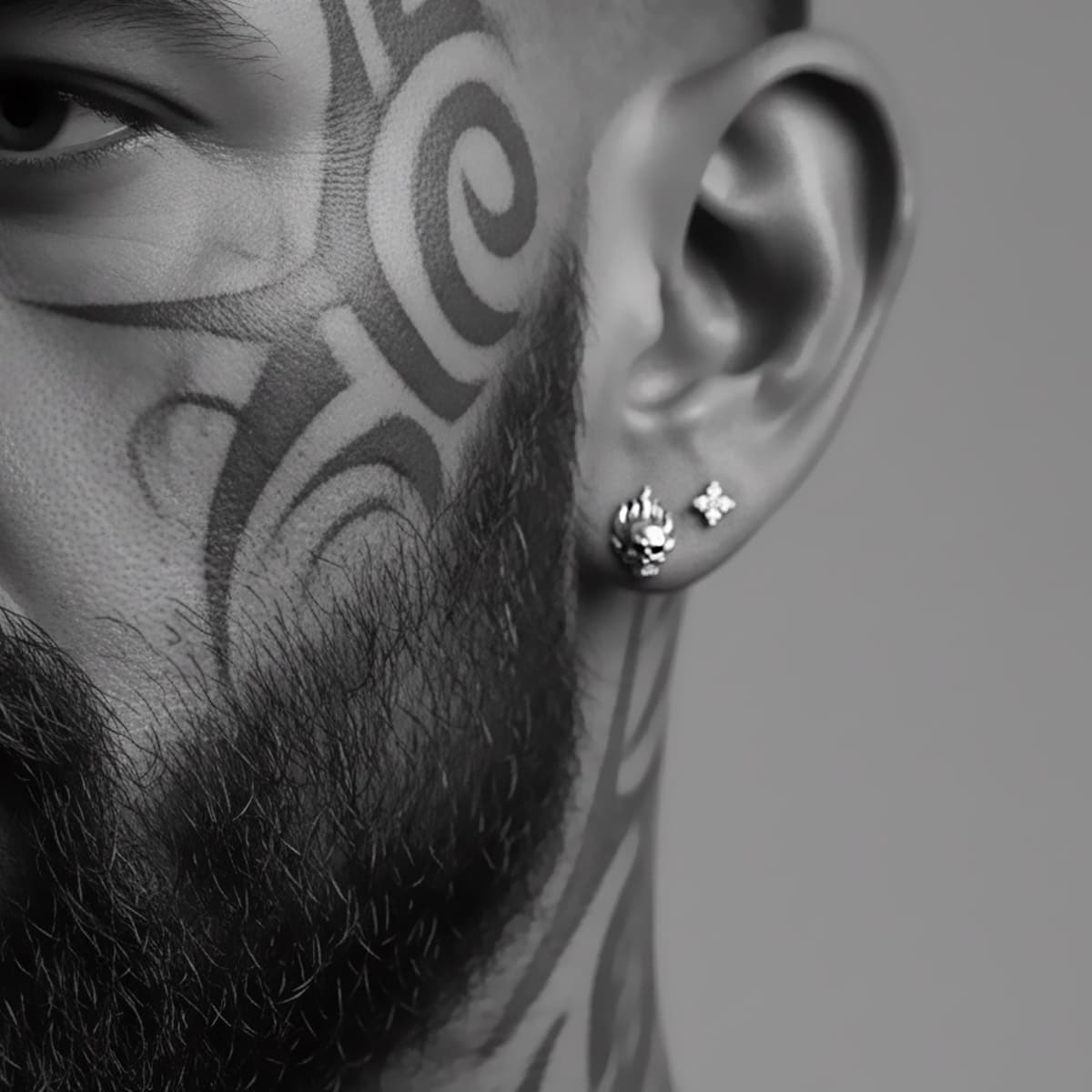 close-up flame skull earrings on rugged biker man with beard and face tattoos