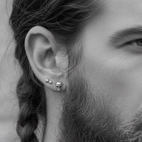 silver horned demon skull earring in biker mans ear