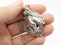 laughing gargoyle silver pendant in models hand showing depth and size 