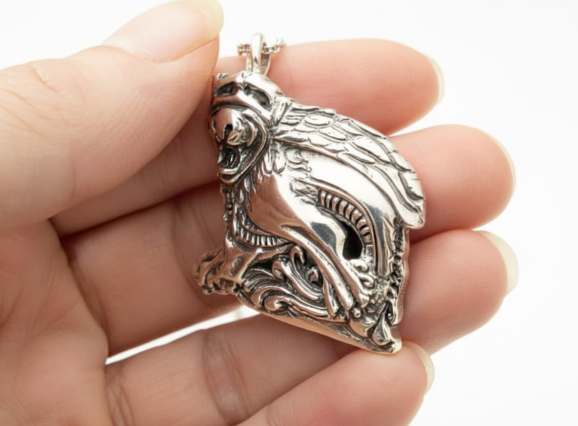 laughing gargoyle silver pendant in models hand showing depth and size 