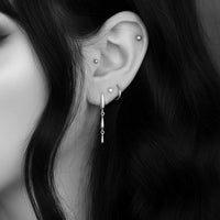 close-up of silver cascade gothic teardrop earrings on alternative women with romantic long dark hair 