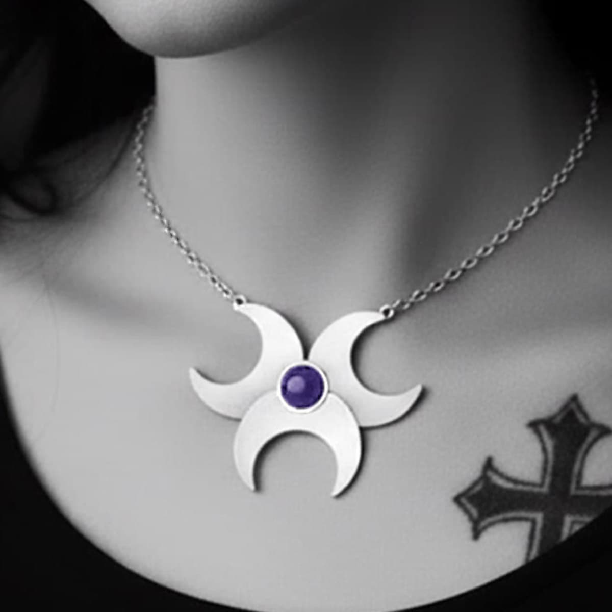 close up of unusual silver moon pendant with purple amethyst on a choker 